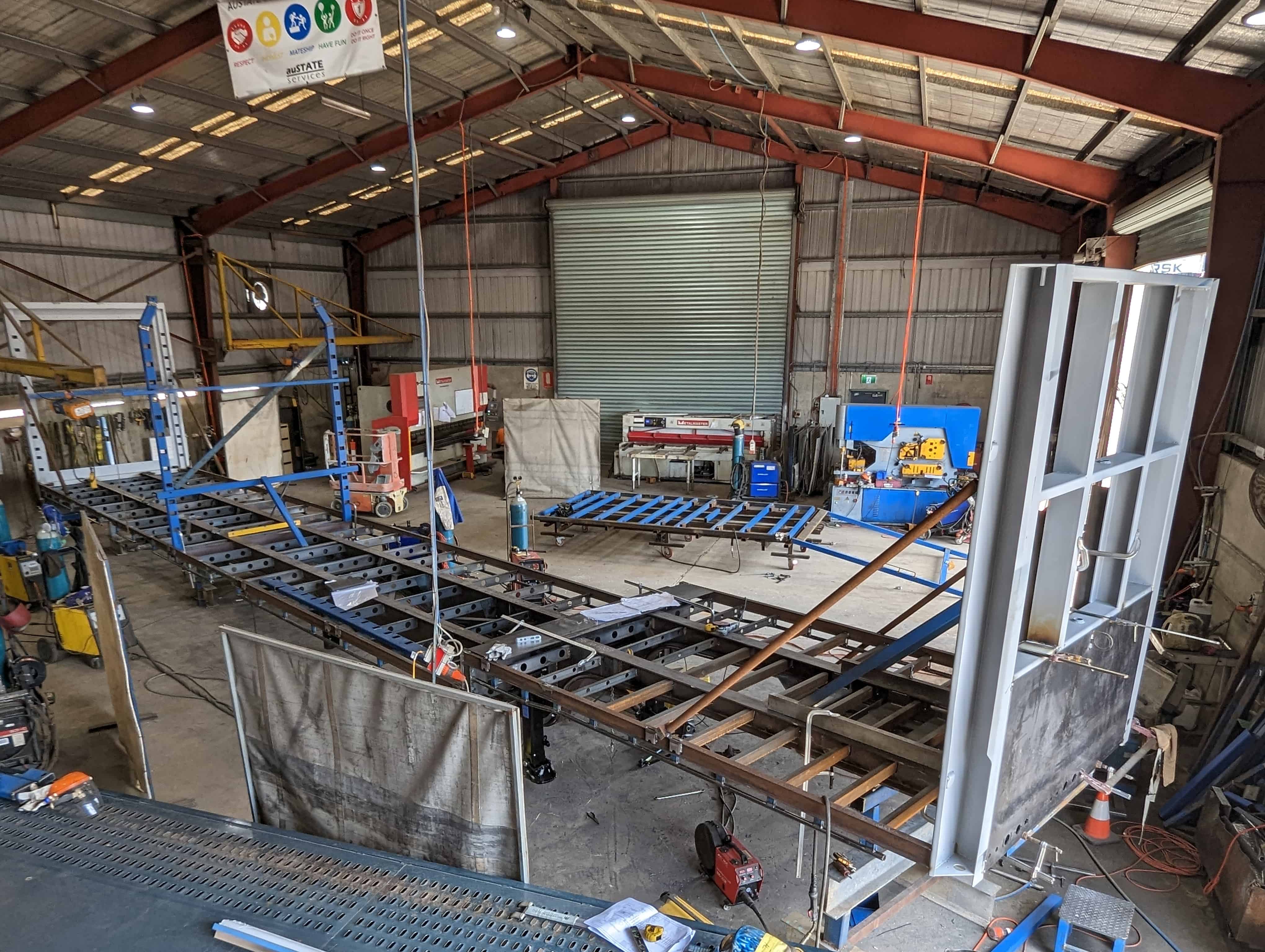 Heavy trailer chassis and frame assemblies progressing through workshop fabrication