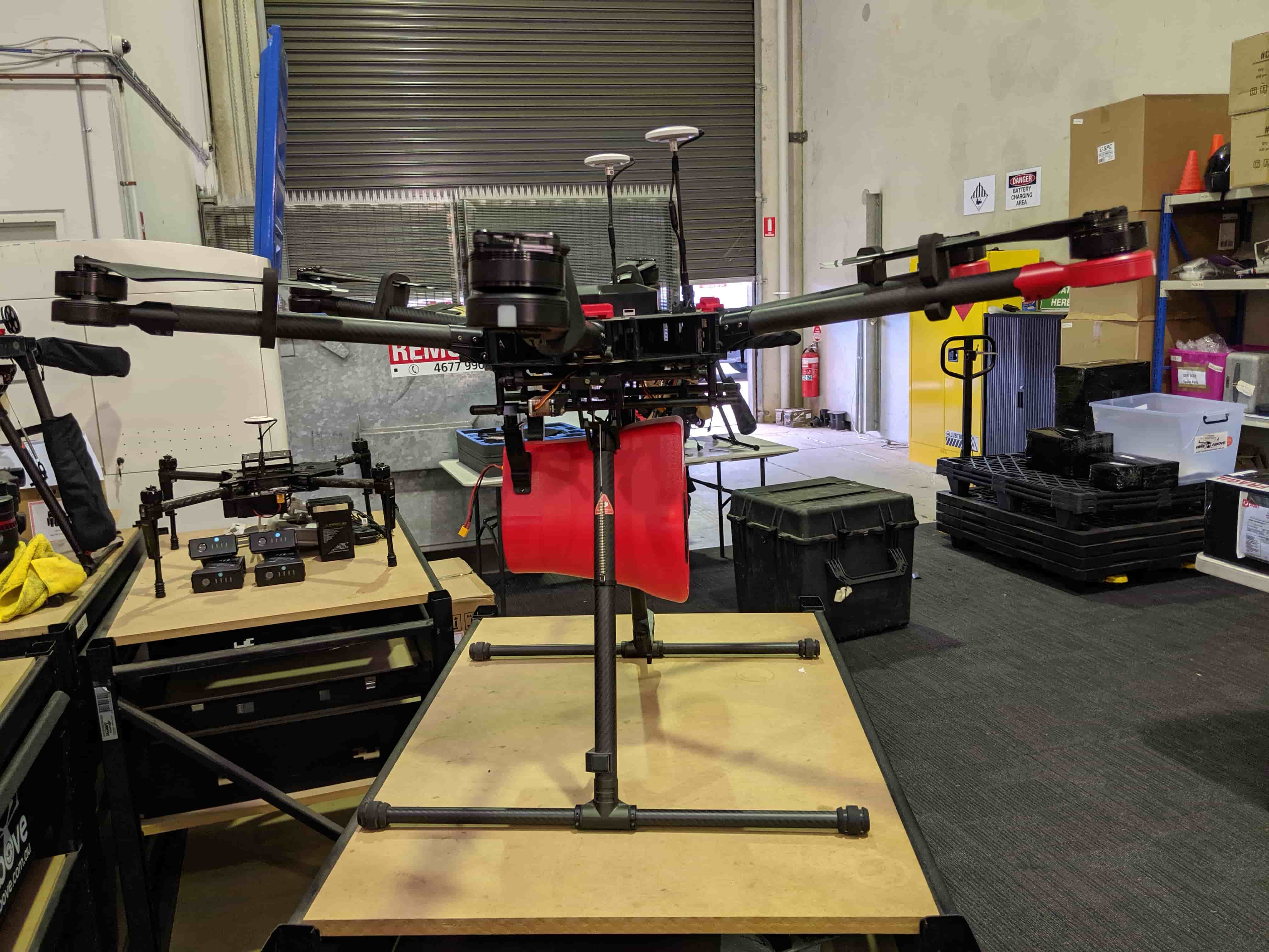 Rear workshop view of the megaphone payload mounted beneath the multirotor aircraft