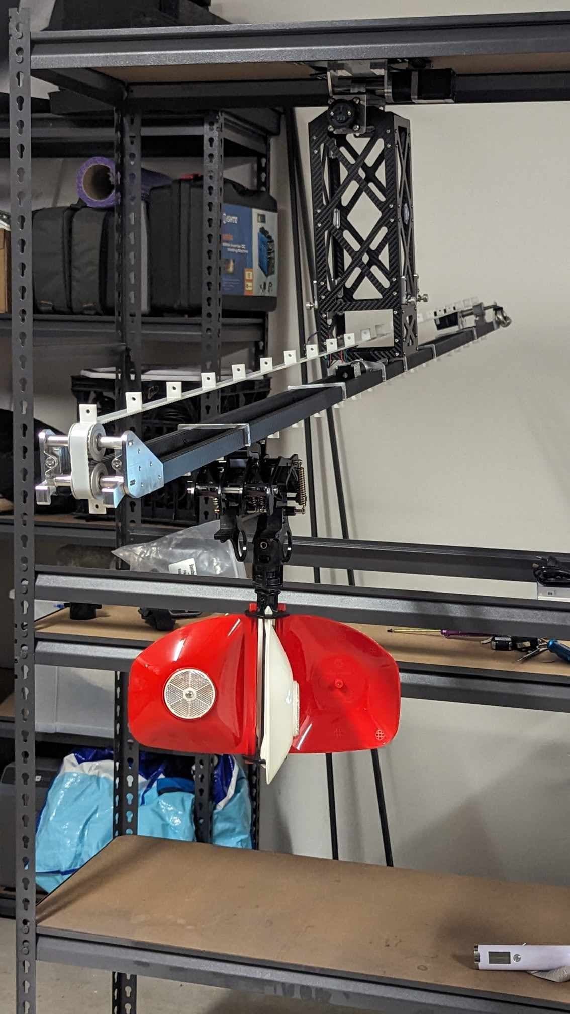 Payload mechanism holding a red Rotamarka warning marker during a bench installation test