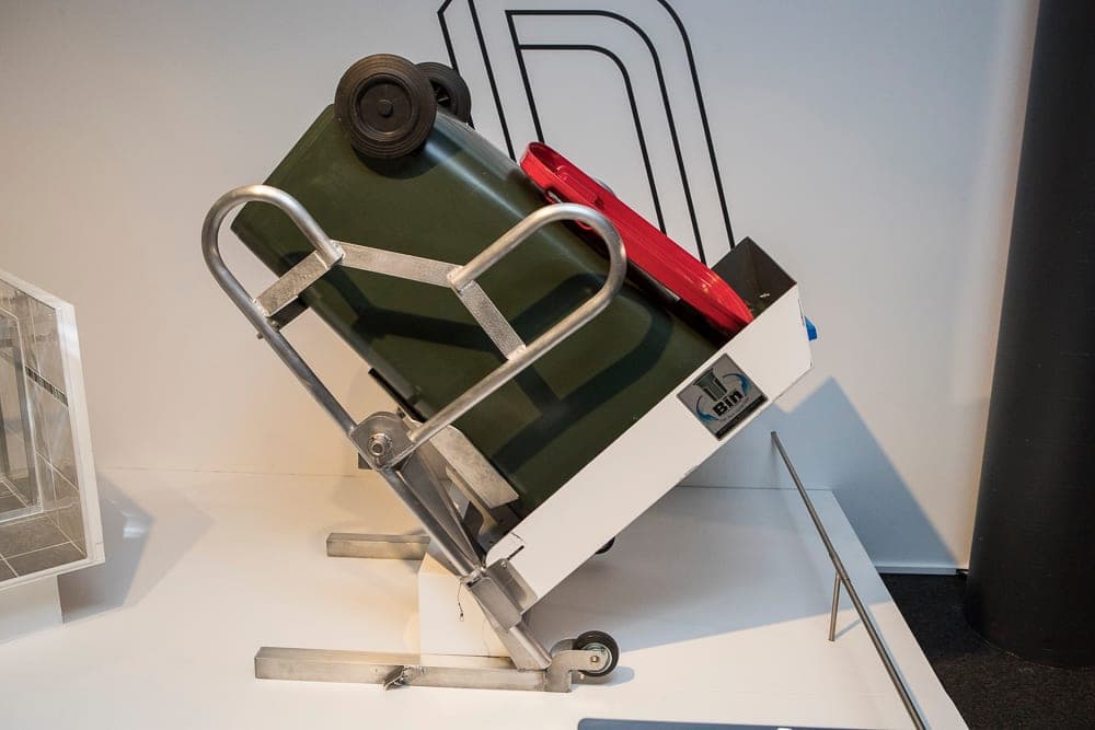 T-Bin prototype displayed from the side with a green wheelie bin rotated into its cleaning position