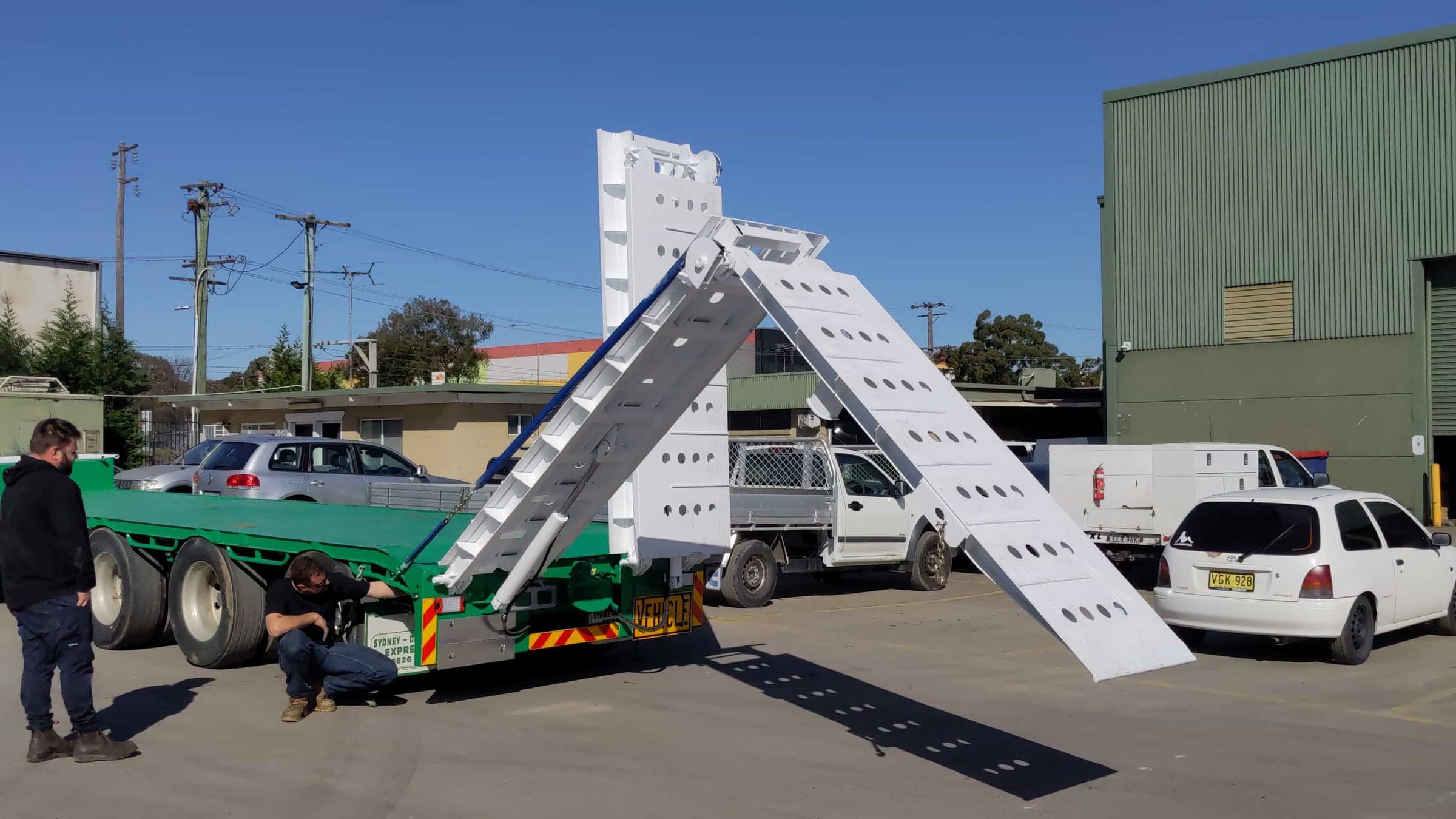 Heavy truck ramp partway through its folding and stowing motion