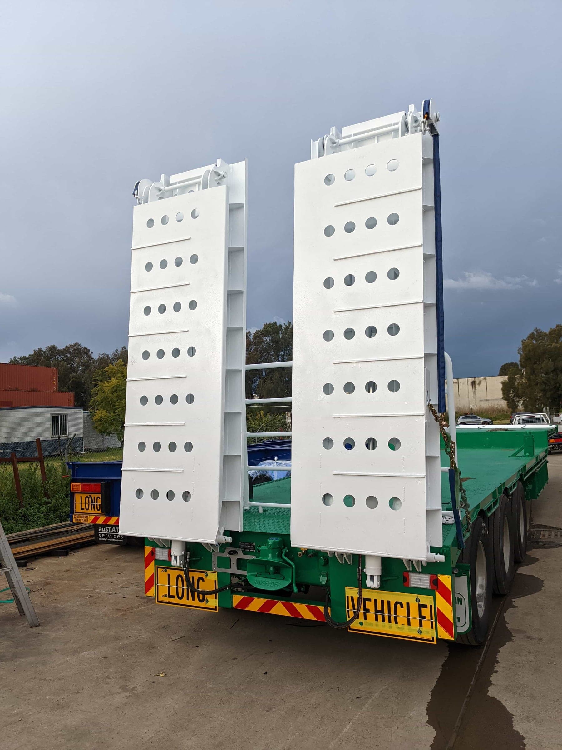 Pair of heavy truck ramps secured upright in their stowed position